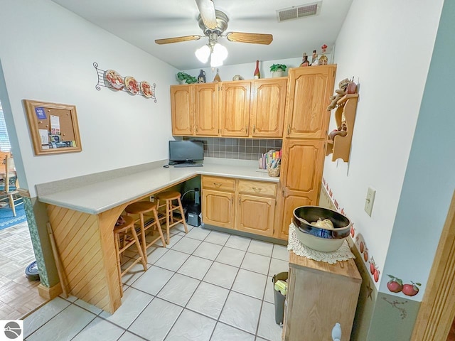 4809 N Alamando Rd, Coleman, MI 48618 - kitchen featuring light countertops, backsplash, ceiling fan, light tile patterned flooring, and light brown cabinetry