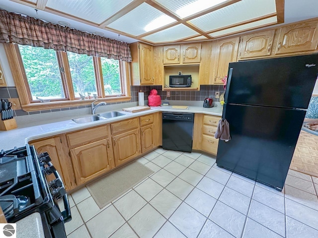 4809 N Alamando Rd, Coleman, MI 48618 - kitchen with black appliances, a sink, light countertops, backsplash, and light tile patterned floors