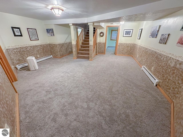4809 N Alamando Rd, Coleman, MI 48618 - finished below grade area featuring carpet, stairway, a wainscoted wall, a baseboard heating unit, and a textured ceiling