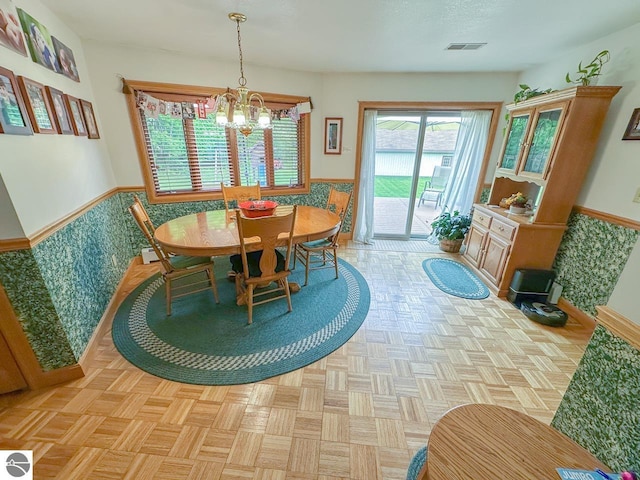 4809 N Alamando Rd, Coleman, MI 48618 - dining space featuring a chandelier, a wainscoted wall, and baseboards