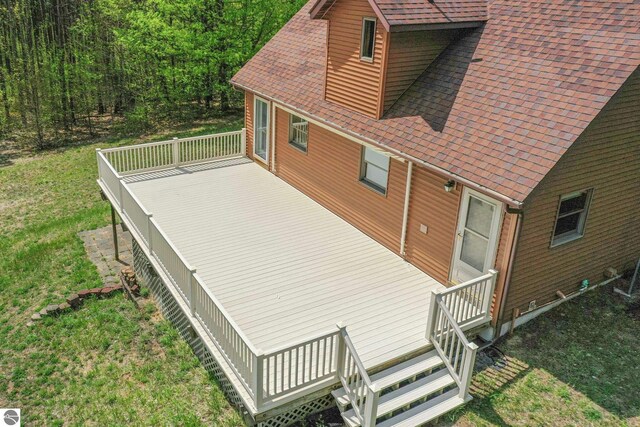 2460 E 26th Rd, Cadillac, MI 49601 - view of side of home with a shingled roof, a yard, and a deck