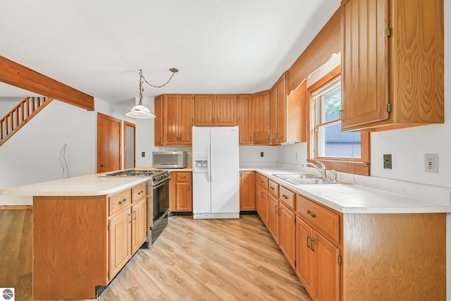 2460 E 26th Rd, Cadillac, MI 49601 - kitchen featuring white refrigerator with ice dispenser, gas range oven, stainless steel microwave, a sink, and light wood-style floors