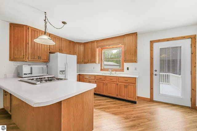 2460 E 26th Rd, Cadillac, MI 49601 - kitchen with white appliances, light countertops, light wood-style floors, and a sink