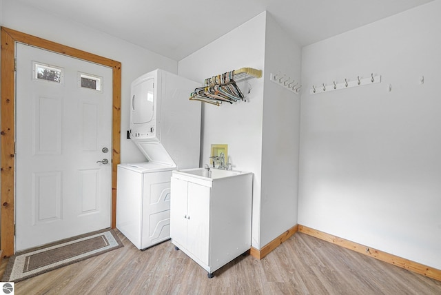 2460 E 26th Rd, Cadillac, MI 49601 - laundry area with estacked washer and dryer, light wood-type flooring, baseboards, and cabinet space