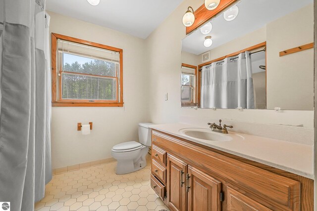 2460 E 26th Rd, Cadillac, MI 49601 - bathroom with vanity, toilet, a shower with shower curtain, baseboards, and tile patterned floors