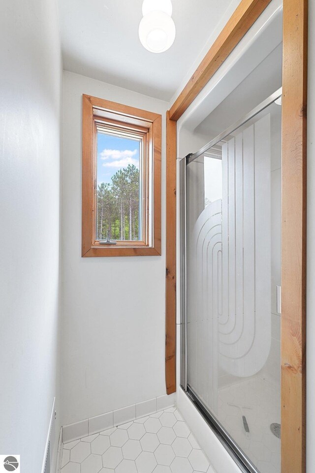 2460 E 26th Rd, Cadillac, MI 49601 - bathroom with a stall shower, tile patterned flooring, and baseboards