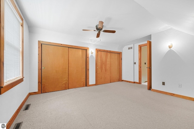 2460 E 26th Rd, Cadillac, MI 49601 - unfurnished bedroom featuring two closets, baseboards, light carpet, and vaulted ceiling