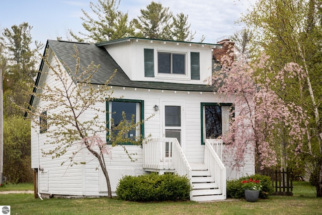 5434 W Macfarlane Rd, Glen Arbor, MI 49636 - traditional-style house with roof with shingles and a front lawn