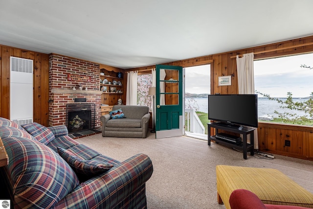 5434 W Macfarlane Rd, Glen Arbor, MI 49636 - living room featuring a heating unit, wooden walls, carpet, and a brick fireplace