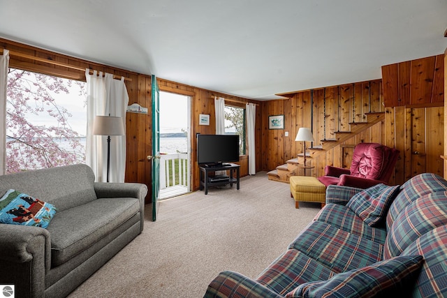 5434 W Macfarlane Rd, Glen Arbor, MI 49636 - living room with light colored carpet, stairway, and wood walls