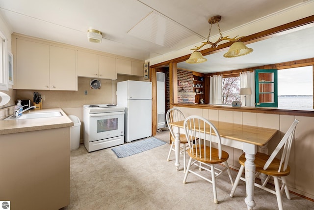 5434 W Macfarlane Rd, Glen Arbor, MI 49636 - kitchen featuring white appliances, a sink, cream cabinetry, light countertops, and decorative light fixtures