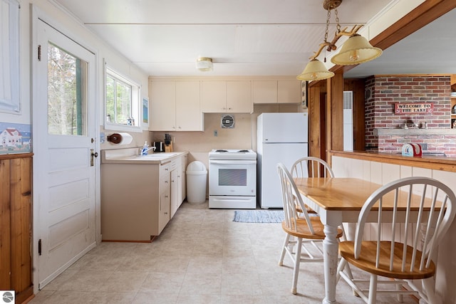5434 W Macfarlane Rd, Glen Arbor, MI 49636 - kitchen featuring white appliances, light tile patterned flooring, hanging light fixtures, light countertops, and white cabinets