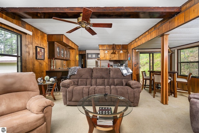 1912 Rosenburg Rd, Kalkaska, MI 49646 - living area featuring light colored carpet, wood walls, and a ceiling fan