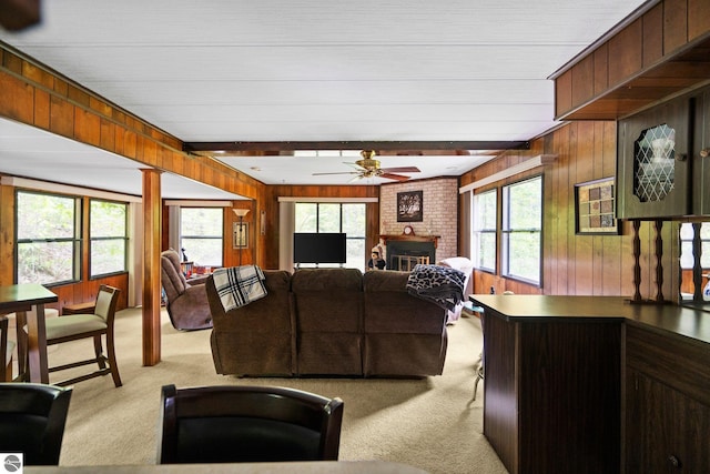1912 Rosenburg Rd, Kalkaska, MI 49646 - living area with light colored carpet, wood walls, ceiling fan, and a brick fireplace