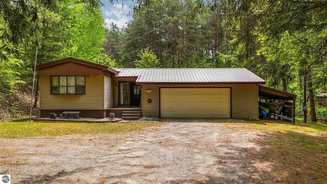 1912 Rosenburg Rd, Kalkaska, MI 49646 - view of front of home featuring driveway, metal roof, and a garage