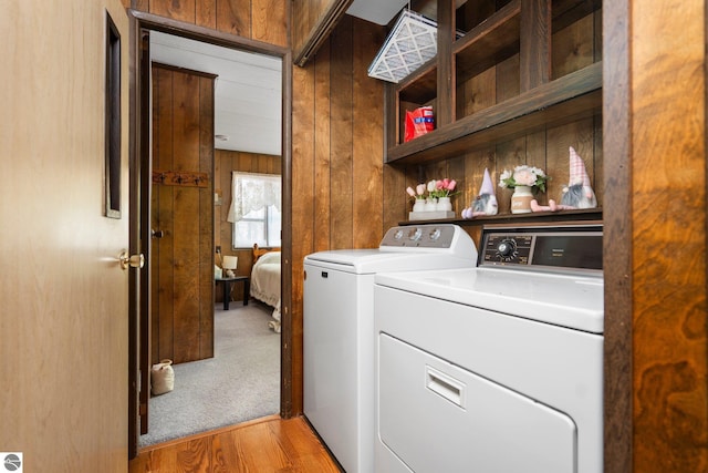 1912 Rosenburg Rd, Kalkaska, MI 49646 - laundry room with washing machine and clothes dryer, wooden walls, and light wood-type flooring