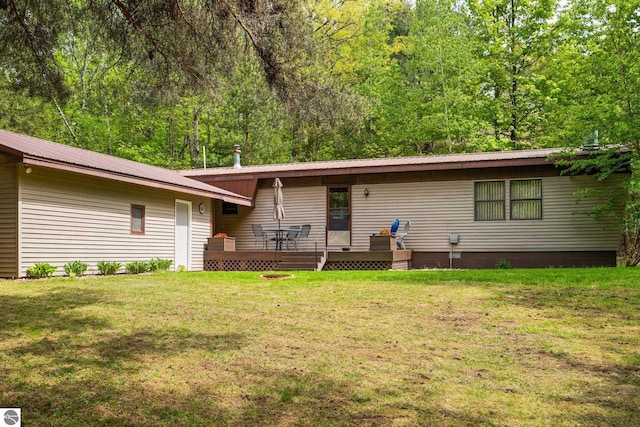 1912 Rosenburg Rd, Kalkaska, MI 49646 - view of front of house with a front yard, metal roof, and a deck