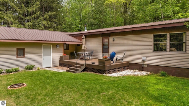 1912 Rosenburg Rd, Kalkaska, MI 49646 - rear view of property featuring a deck, metal roof, and a lawn