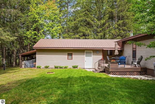 1912 Rosenburg Rd, Kalkaska, MI 49646 - back of house featuring a wooden deck, a lawn, and metal roof