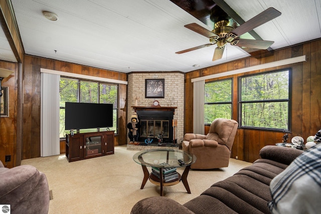 1912 Rosenburg Rd, Kalkaska, MI 49646 - carpeted living area featuring wooden walls, plenty of natural light, a brick fireplace, and ceiling fan
