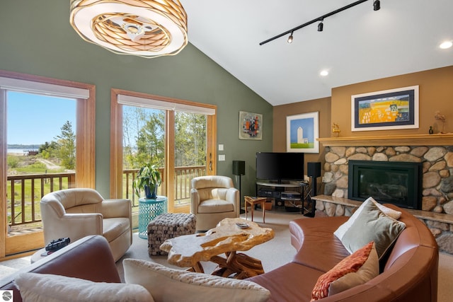 11896 Cabana Shores Rd, Williamsburg, MI 49690 - living room with lofted ceiling, track lighting, a stone fireplace, carpet, and recessed lighting