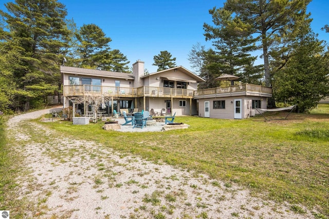 11896 Cabana Shores Rd, Williamsburg, MI 49690 - rear view of property featuring an outdoor fire pit, a wooden deck, a yard, a patio, and a chimney