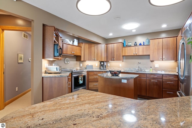 11896 Cabana Shores Rd, Williamsburg, MI 49690 - kitchen with stainless steel appliances, a sink, light stone countertops, and brown cabinets