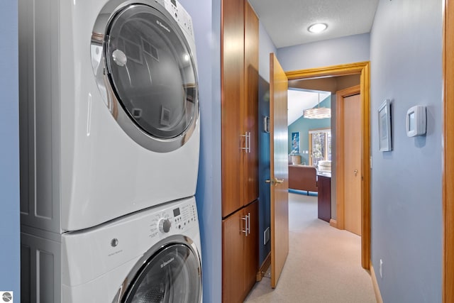 11896 Cabana Shores Rd, Williamsburg, MI 49690 - laundry area featuring stacked washer / dryer, light carpet, cabinet space, baseboards, and a textured ceiling