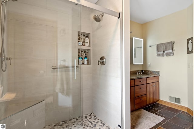 11896 Cabana Shores Rd, Williamsburg, MI 49690 - full bath with a shower stall, vanity, baseboards, and stone finish floors
