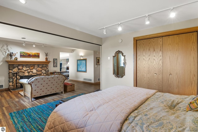 11896 Cabana Shores Rd, Williamsburg, MI 49690 - bedroom featuring track lighting, wood finished floors, a closet, and baseboards