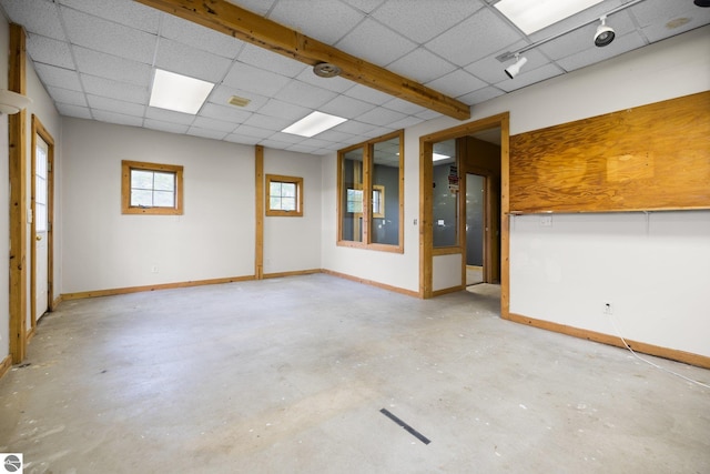 6675 Walker St, Benzonia, MI 49616 - unfurnished room with unfinished concrete floors, a paneled ceiling, and baseboards