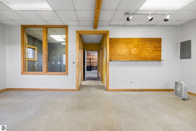 6675 Walker St, Benzonia, MI 49616 - unfurnished room with electric panel, baseboards, a drop ceiling, and concrete floors