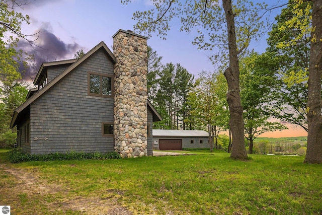 6675 Walker St, Benzonia, MI 49616 - property exterior at dusk with a chimney, a garage, and a lawn