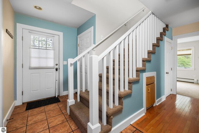 6675 Walker St, Benzonia, MI 49616 - entryway with stairs, healthy amount of natural light, baseboard heating, and baseboards