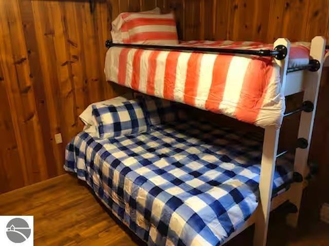 2401 J Maddy Pkwy, Interlochen, MI 49643 - bedroom featuring wood finished floors and wood walls