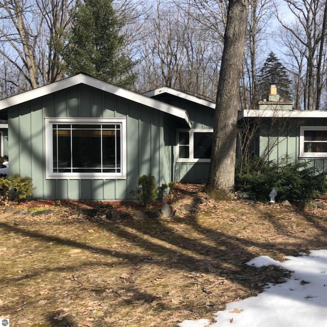 2401 J Maddy Pkwy, Interlochen, MI 49643 - view of home's exterior featuring board and batten siding and a chimney