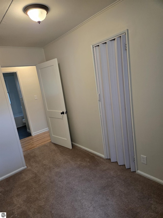 1023 S Elizabeth St, Mount Pleasant, MI 48858 - unfurnished bedroom with ornamental molding, carpet, baseboards, and a closet