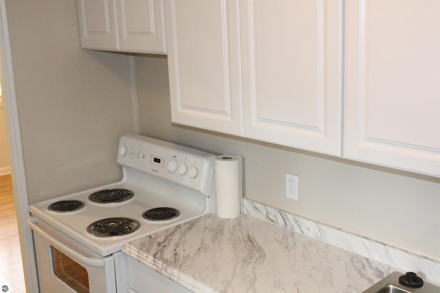 1023 S Elizabeth St, Mount Pleasant, MI 48858 - kitchen featuring white range with electric stovetop and white cabinets