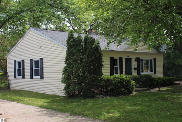 1023 S Elizabeth St, Mount Pleasant, MI 48858 - view of front facade featuring roof with shingles, a front yard, and a chimney
