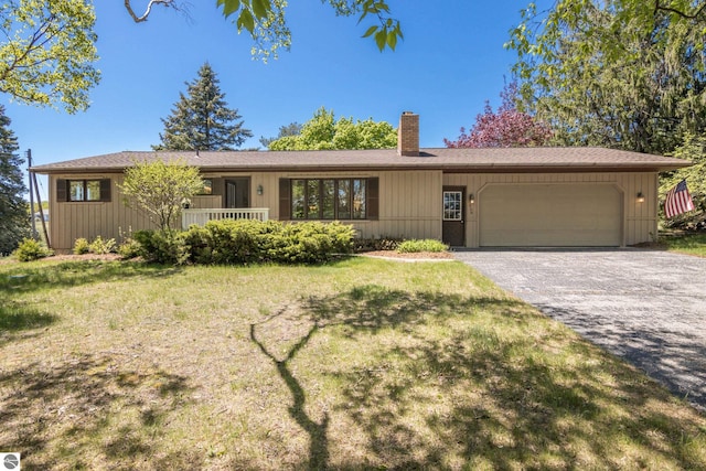 906 Michigan Ave, Frankfort, MI 49635 - ranch-style home with a chimney, a garage, driveway, and a front yard