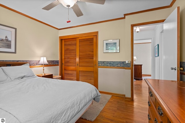 906 Michigan Ave, Frankfort, MI 49635 - bedroom with wood finished floors, crown molding, a closet, wainscoting, and a ceiling fan