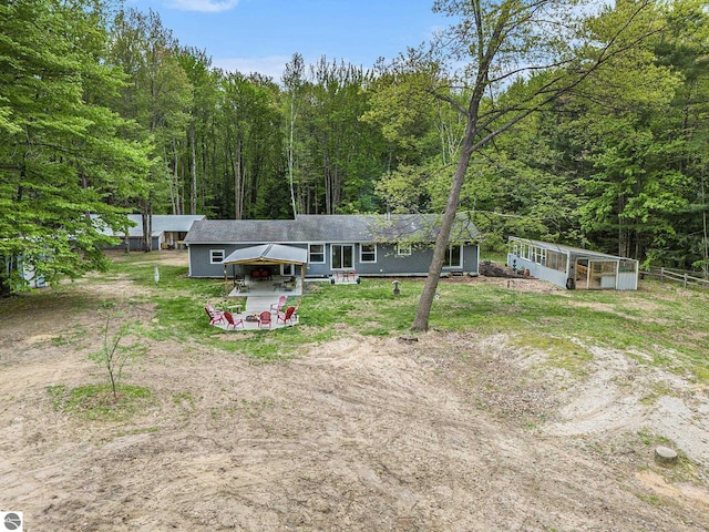 6313 E 34 1/2 Rd, Cadillac, MI 49601 - rear view of property with a forest view, driveway, and an outbuilding