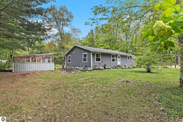 6313 E 34 1/2 Rd, Cadillac, MI 49601 - back of house featuring a lawn and a sunroom