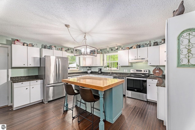6313 E 34 1/2 Rd, Cadillac, MI 49601 - kitchen featuring stainless steel appliances, butcher block countertops, a chandelier, white cabinets, and a textured ceiling