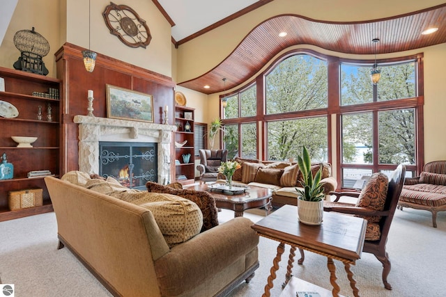 6853 S W Bay Shore Dr, Traverse City, MI 49684 - carpeted living room with high vaulted ceiling, a warm lit fireplace, ornamental molding, and recessed lighting