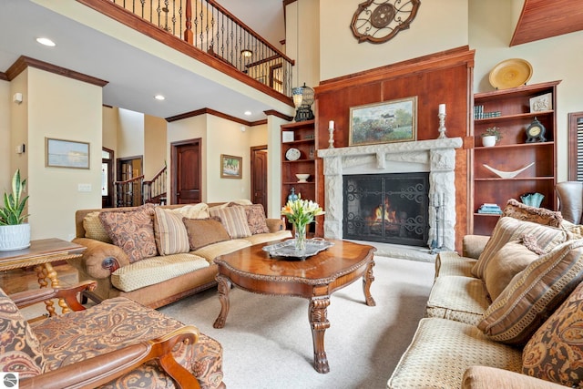 6853 S W Bay Shore Dr, Traverse City, MI 49684 - carpeted living room featuring stairway, ornamental molding, a premium fireplace, a towering ceiling, and recessed lighting