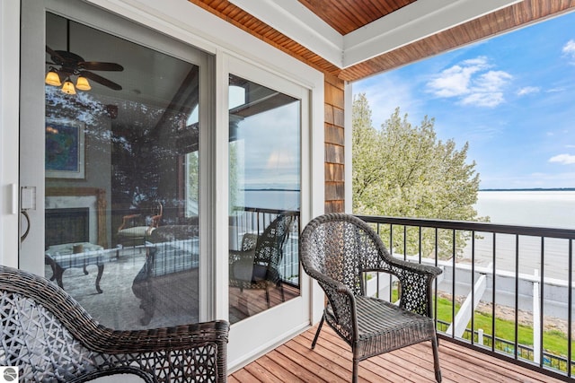 6853 S W Bay Shore Dr, Traverse City, MI 49684 - balcony with a water view, ceiling fan, and a sunroom