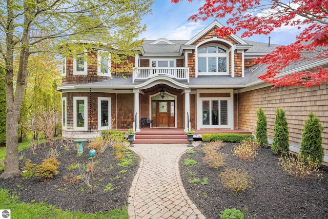 6853 S W Bay Shore Dr, Traverse City, MI 49684 - shingle-style home with a shingled roof, covered porch, and a balcony
