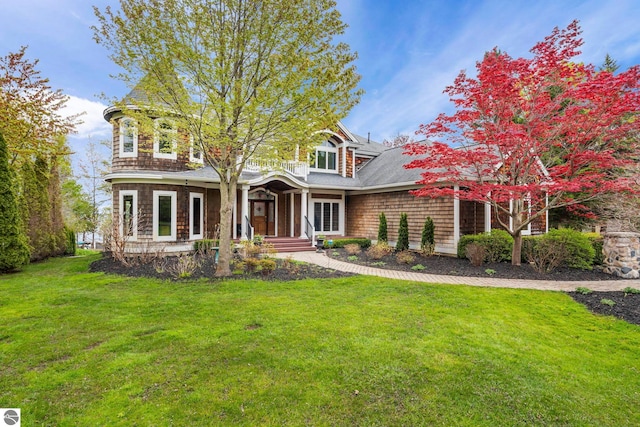 6853 S W Bay Shore Dr, Traverse City, MI 49684 - shingle-style home with a front yard, covered porch, and roof with shingles