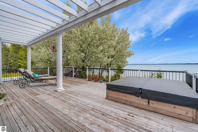 6853 S W Bay Shore Dr, Traverse City, MI 49684 - wooden deck featuring a covered hot tub, a water view, and a pergola